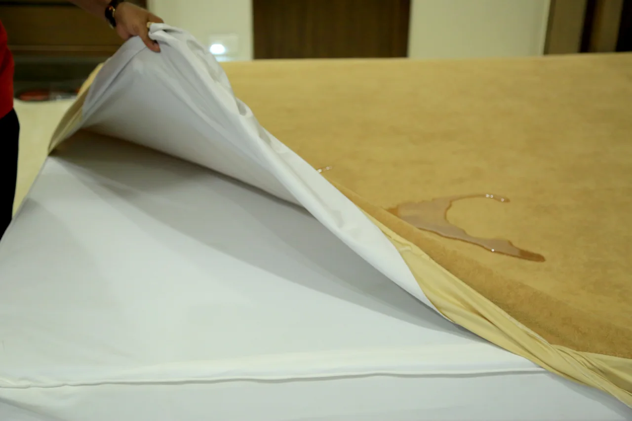 Gold bedding lifted to show its white reverse and the surface underneath